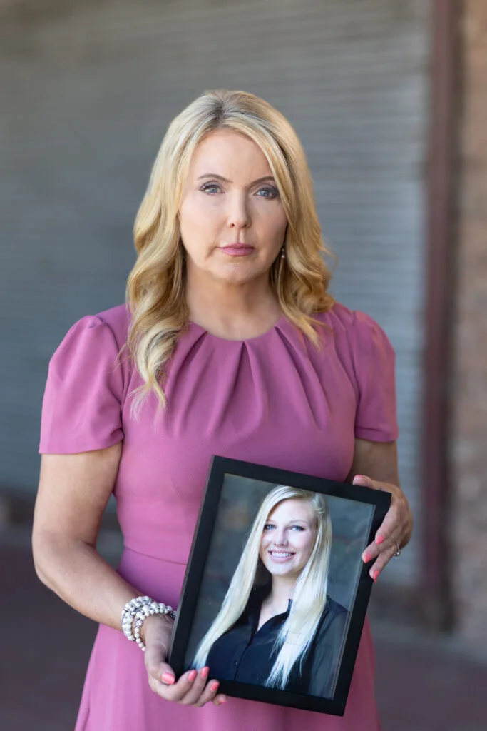Angela Kennecke, founder of Emily's Hope, holding framed photo of daughter Emily Groth